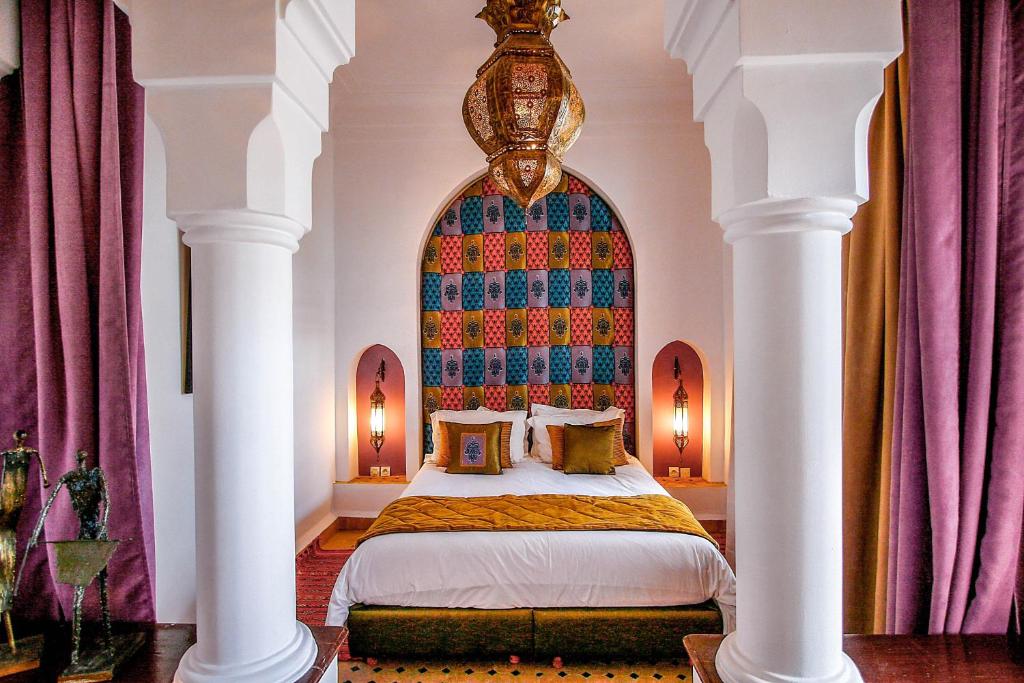 une chambre avec un grand lit avec une grande fenêtre dans l'établissement Riad Villa Almeria Hotel & Spa, à Marrakech