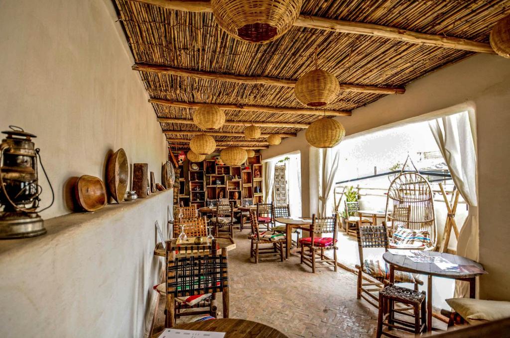 un restaurant avec des chaises et des tables ainsi qu'une salle avec des livres dans l'établissement Riad Villa Almeria Hotel & Spa, à Marrakech