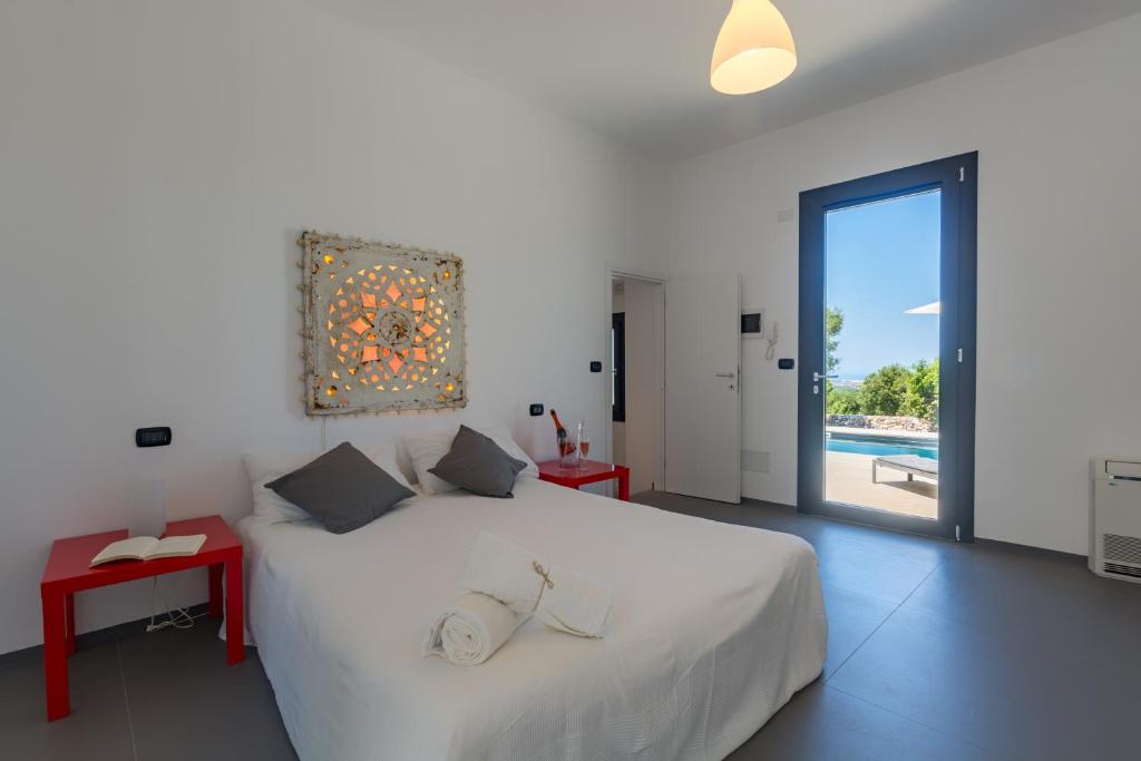 - une chambre avec un grand lit blanc et une piscine dans l'établissement Villa Roberta by HDSalento, à Specchiolla