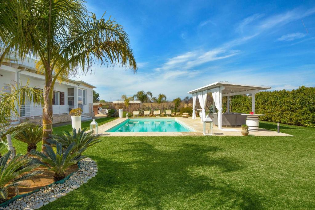 une cour arrière avec une piscine et un gazebo dans l'établissement Villa Padangi by Perle di Puglia, à Gallipoli