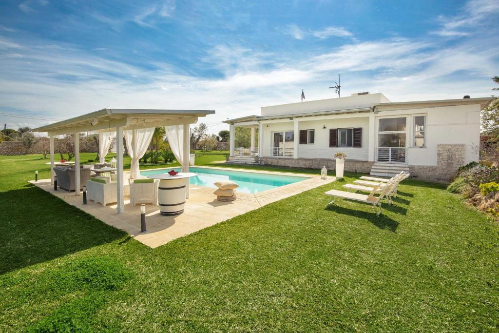 une cour arrière avec une piscine et une maison dans l'établissement Villa Padangi by Perle di Puglia, à Gallipoli
