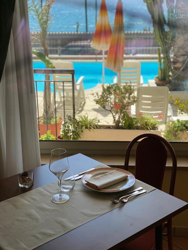 - une table avec une assiette et un verre de vin dans l'établissement Lion's Hotel, à Falerna
