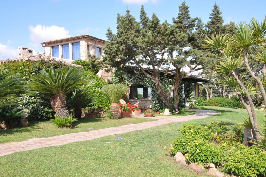 une maison avec des palmiers et un jardin dans l'établissement Luxury Villa Porto Rotondo with private pool by Varental, à Porto Rotondo