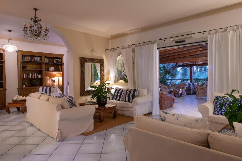 un salon avec des canapés blancs et une table dans l'établissement Boutique Hotel Su Sergenti, à Villasimius