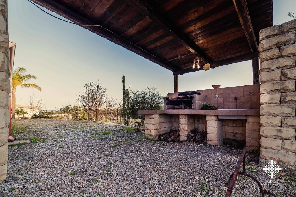 une cuisine extérieure avec un mur en briques dans l'établissement Villa Clara Country Retreat, à Solarino