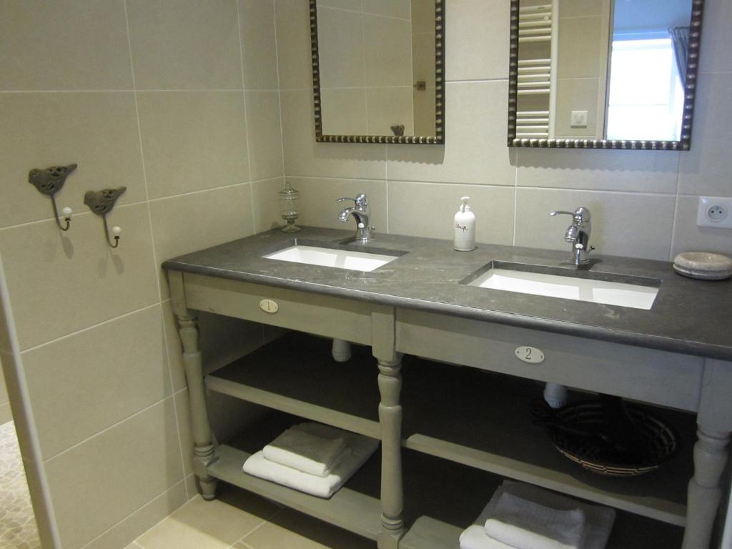une salle de bain avec deux lavabos et un miroir dans l'établissement Clarberg - Gîte, à Saint-André-de-Roquepertuis