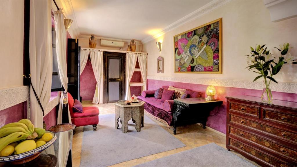 un salon avec un canapé rose et une table dans l'établissement Riad Dar El Souk, à Marrakech