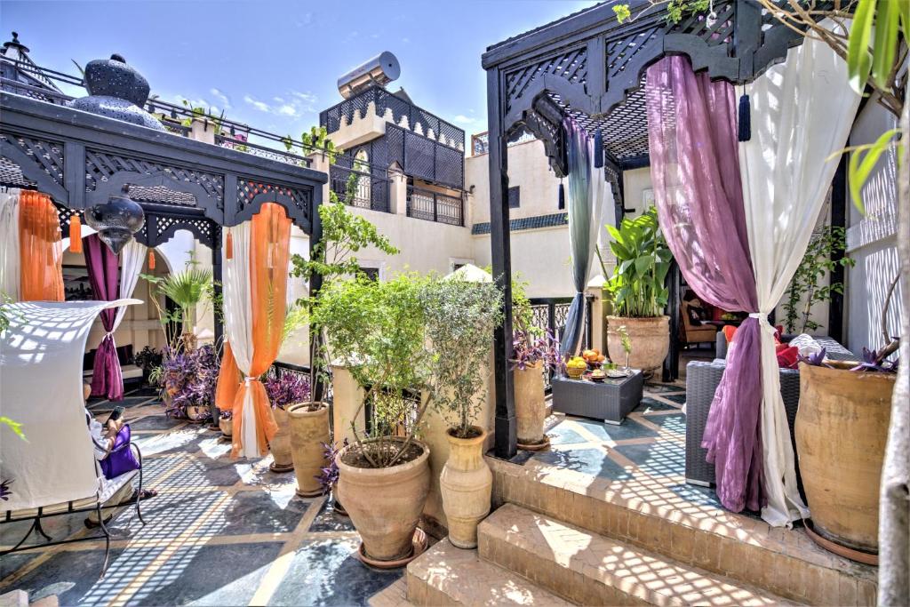 une terrasse avec des plantes en pot et des parasols dans l'établissement Riad Dar El Souk, à Marrakech