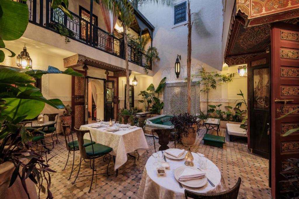 un restaurant avec des tables, des chaises et des plantes dans l'établissement Riad Dar El Souk, à Marrakech