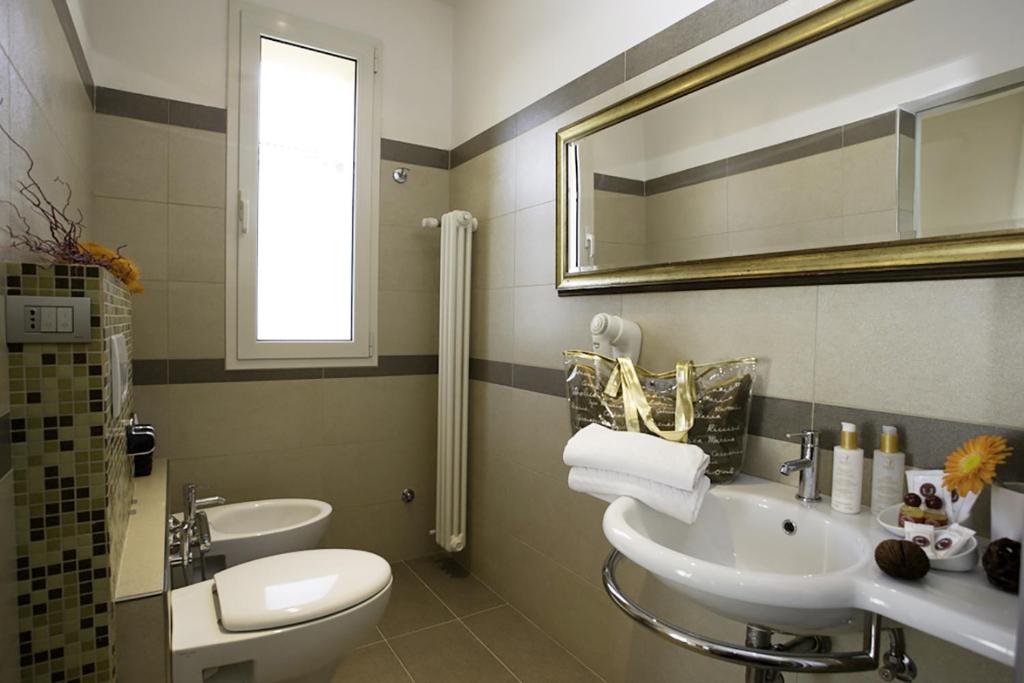 une salle de bain avec un lavabo, des toilettes et un miroir dans l'établissement Hotel b&b Villa Irma, à Rimini