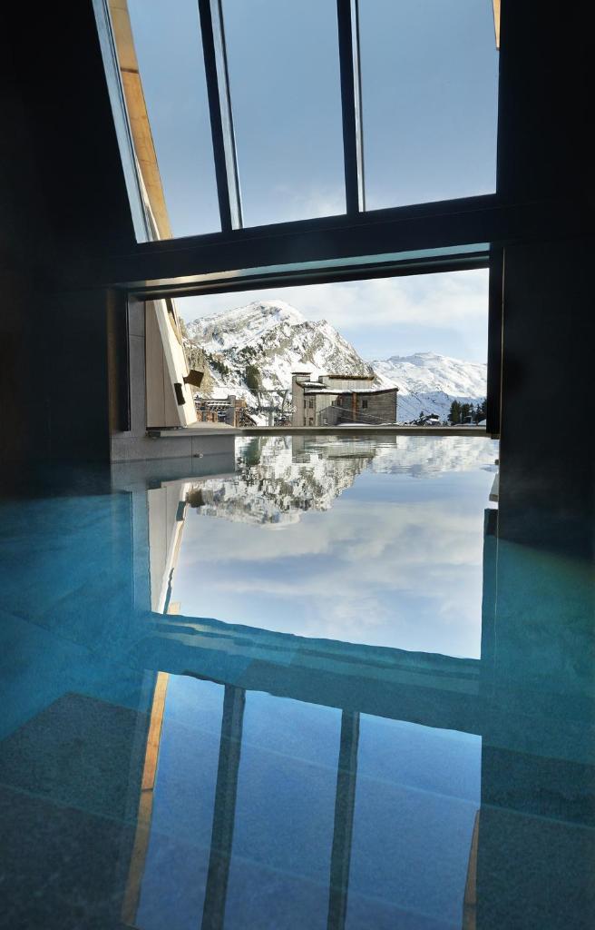 Cette chambre dispose d'une fenêtre offrant une vue sur une montagne enneigée. dans l'établissement Hôtel MiL8, à Avoriaz
