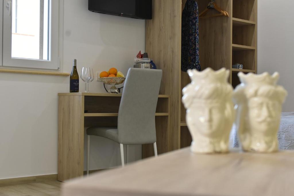 deux vases blancs assis sur une table dans une pièce dans l'établissement Salsedine Tropea Capo Vaticano, à Santa Domenica