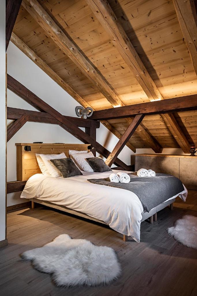 une chambre avec un grand lit avec des draps et des oreillers blancs dans l'établissement Nouveau et spacieux, Place de l'Eglise et terrasse privative, à La Clusaz