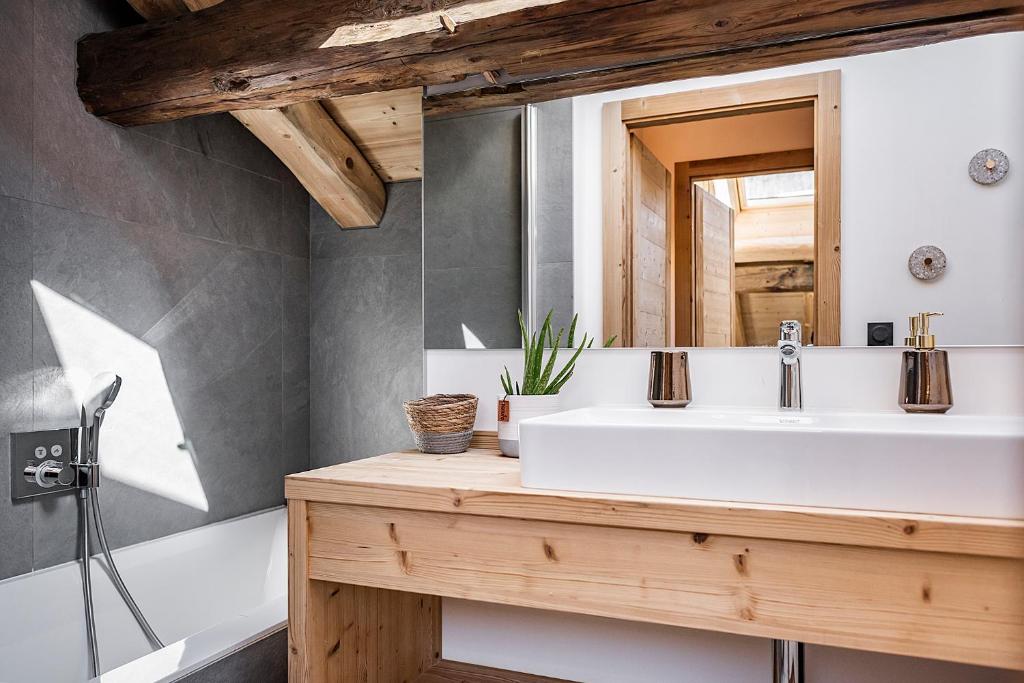une salle de bain avec un lavabo blanc et un miroir dans l'établissement Nouveau et spacieux, Place de l'Eglise et terrasse privative, à La Clusaz