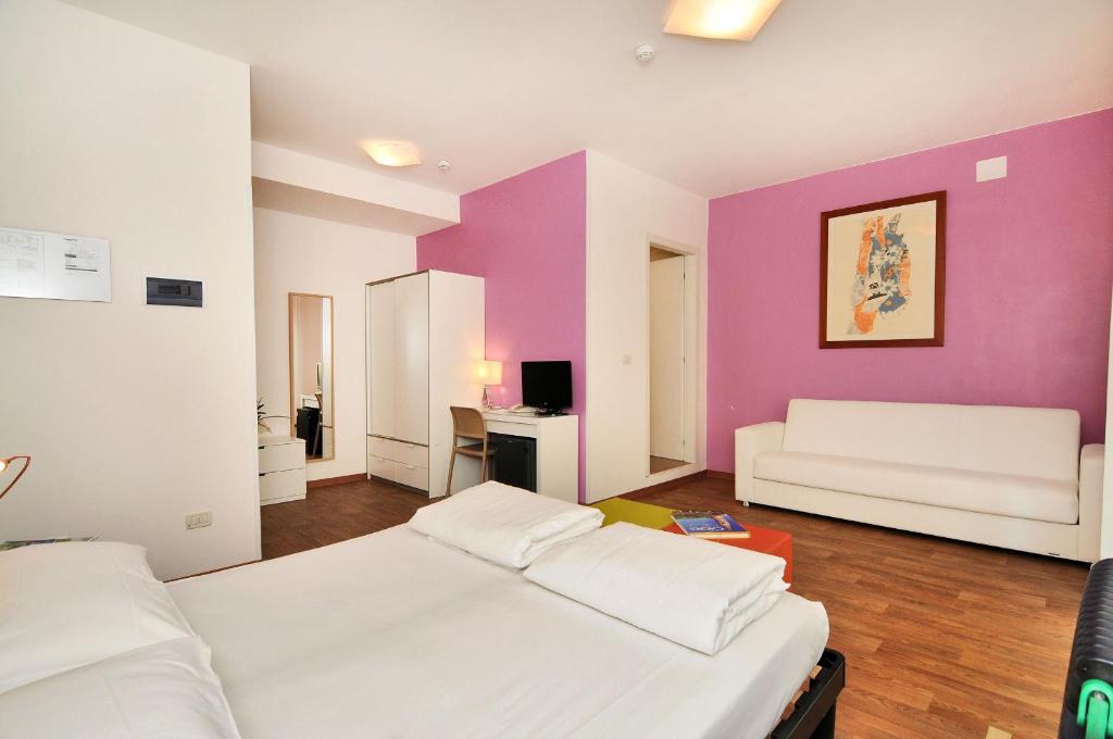 - une chambre avec 2 lits et un mur violet dans l'établissement Hotel Nederland, à Caorle