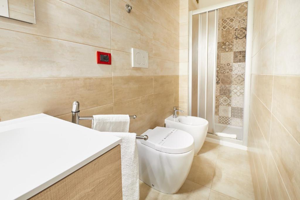 une salle de bain avec toilettes et lavabo dans l'établissement Lilium Maris Hotel, à Bibione