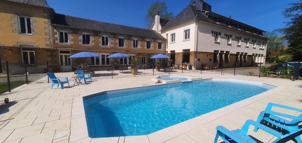 une grande piscine avec des chaises bleues et un bâtiment dans l'établissement Cosy Er Lann Gîte Séquoïa, à Val Couesnon
