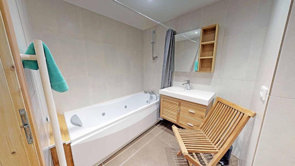La salle de bains est pourvue d'une baignoire blanche, d'un lavabo et de toilettes. dans l'établissement Le Sabot de Vénus, à Val Thorens