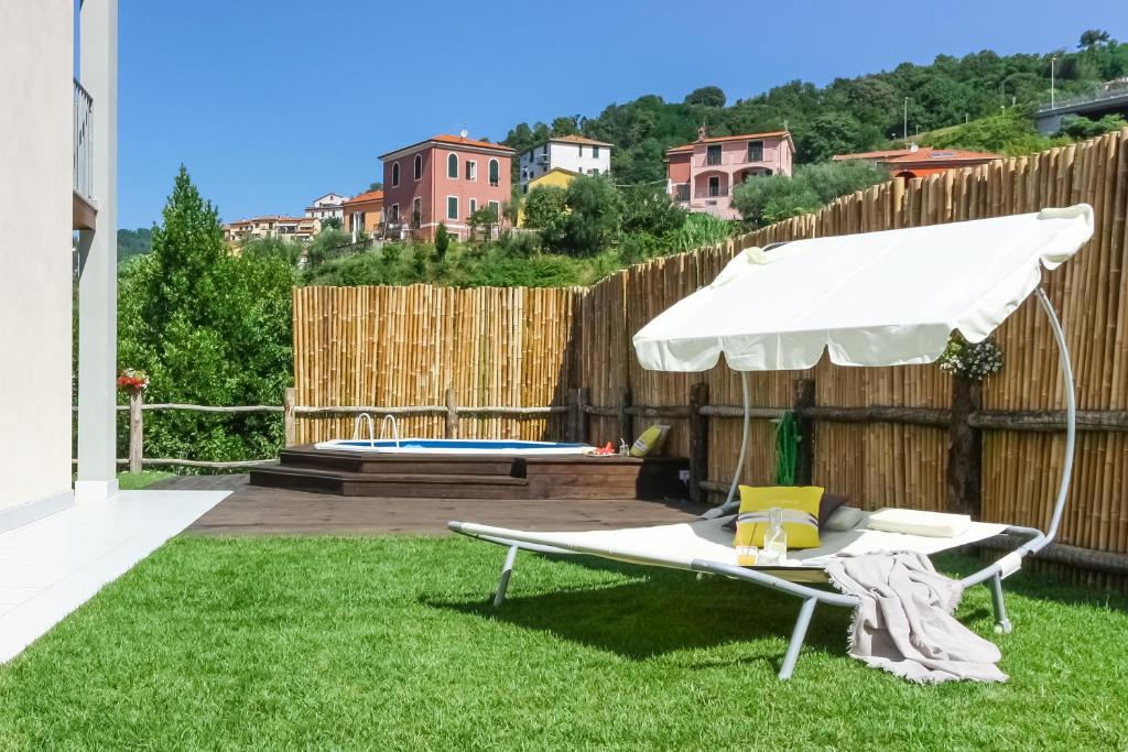 un parasol blanc assis sur l'herbe dans une cour dans l'établissement Luxury Summer House, à La Spezia