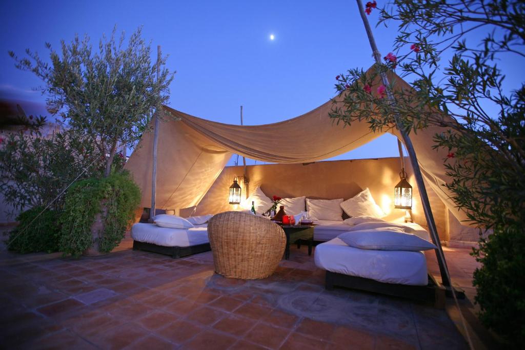 une tente avec deux lits et une table avec des lumières dans l'établissement Riad O2, à Marrakech