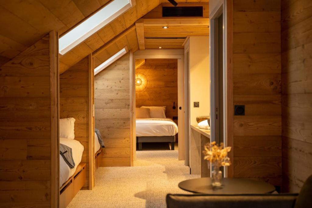 une chambre avec deux lits et une table dans une pièce dans l'établissement Mercure Peyragudes Loudenvielle Pyrénées, à Loudenvielle