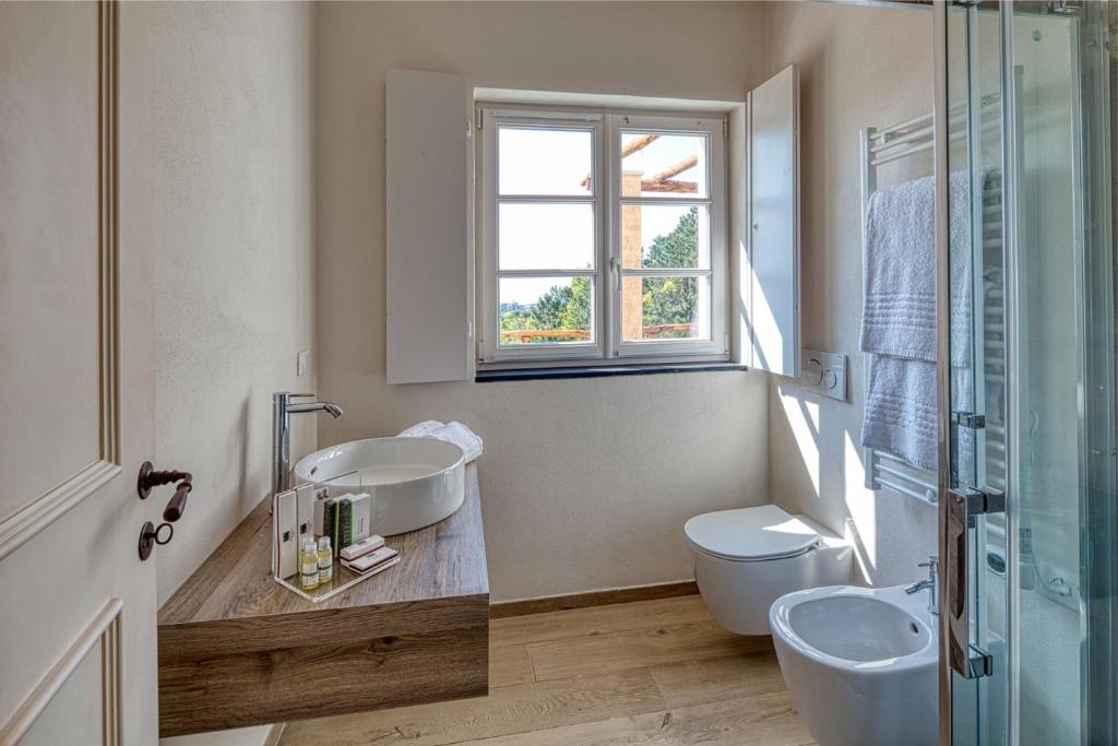 une salle de bain avec deux lavabos et un WC et une fenêtre dans l'établissement Mirandola Suites, à Arenzano