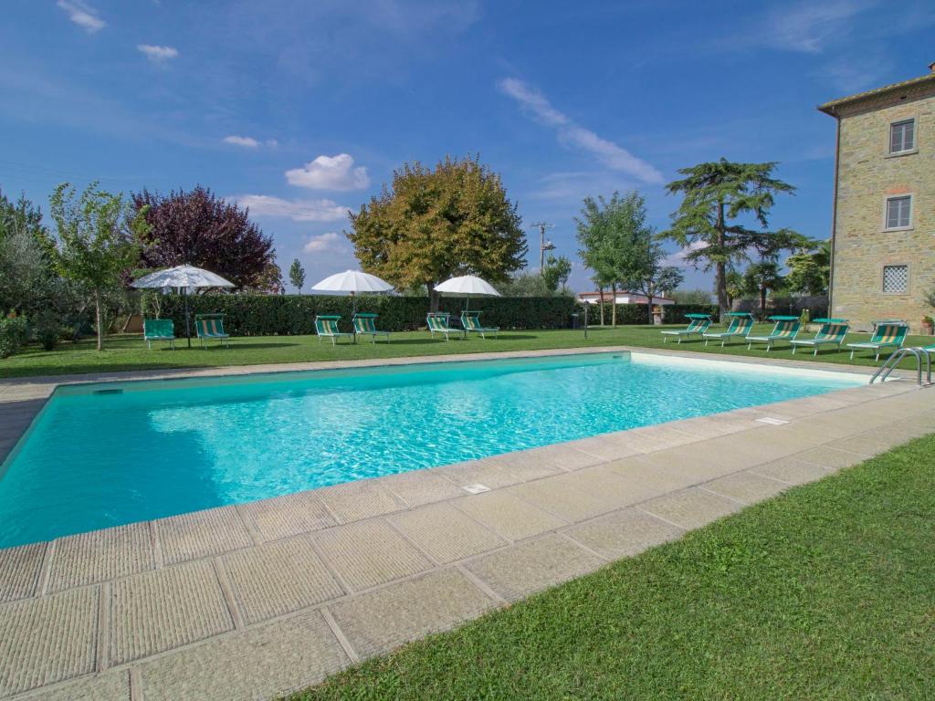 une piscine avec des chaises et un bâtiment dans l'établissement Villa Le Rondini by Interhome, à Cortone