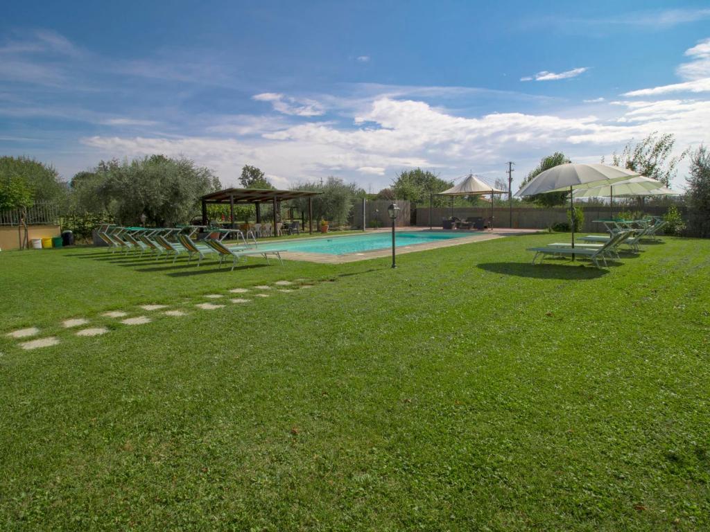 un grand jardin avec une piscine et une aire de jeux dans l'établissement Villa Le Rondini by Interhome, à Cortone