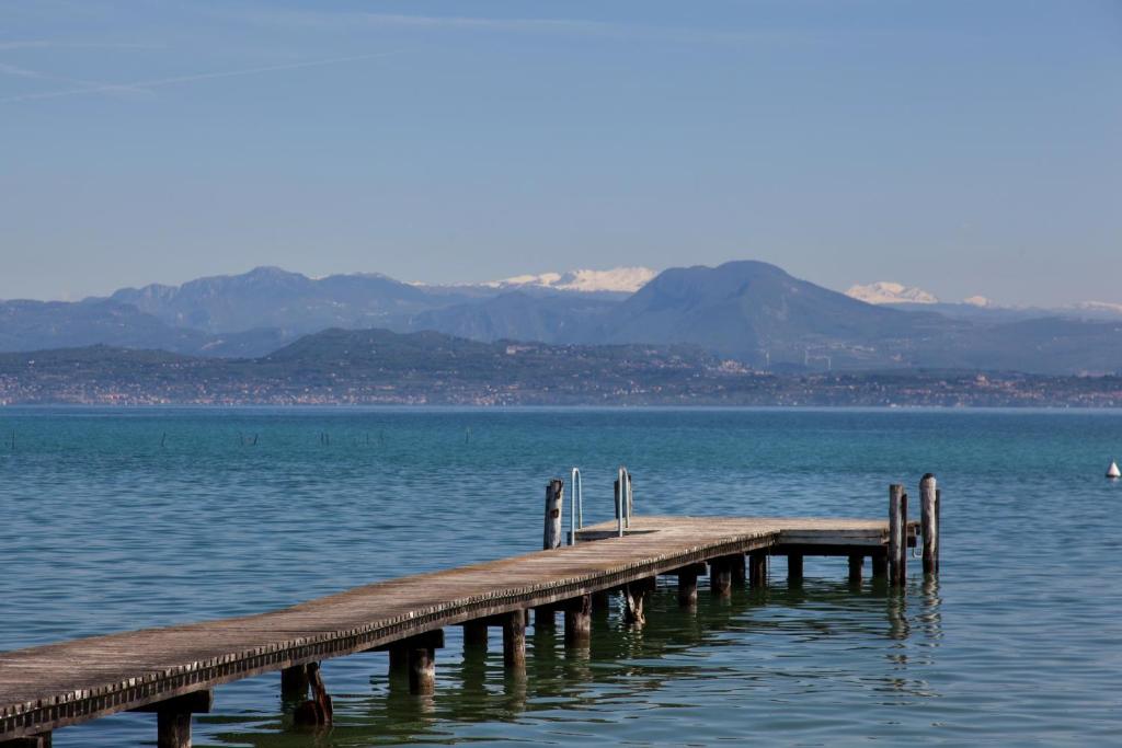 un quai en bois au milieu d'une masse d'eau dans l'établissement Hotel Europa, à Sirmione