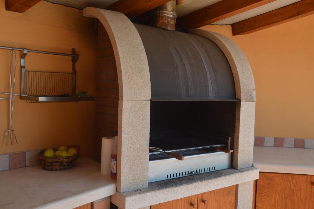 - un four en pierre dans une cuisine avec un bol de pommes dans l'établissement Villa Da Campo, à Giardini Naxos