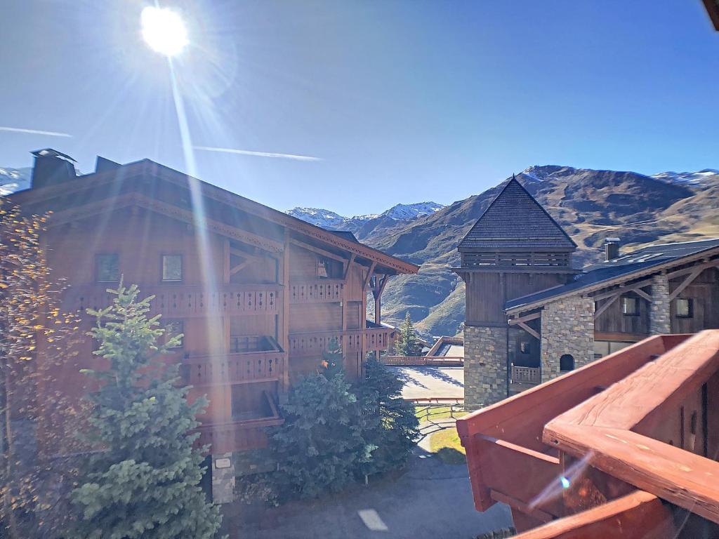 un grand bâtiment avec un soleil brillant sur lui dans l'établissement Les Alpages de Reberty, aux Menuires 1 autre photo