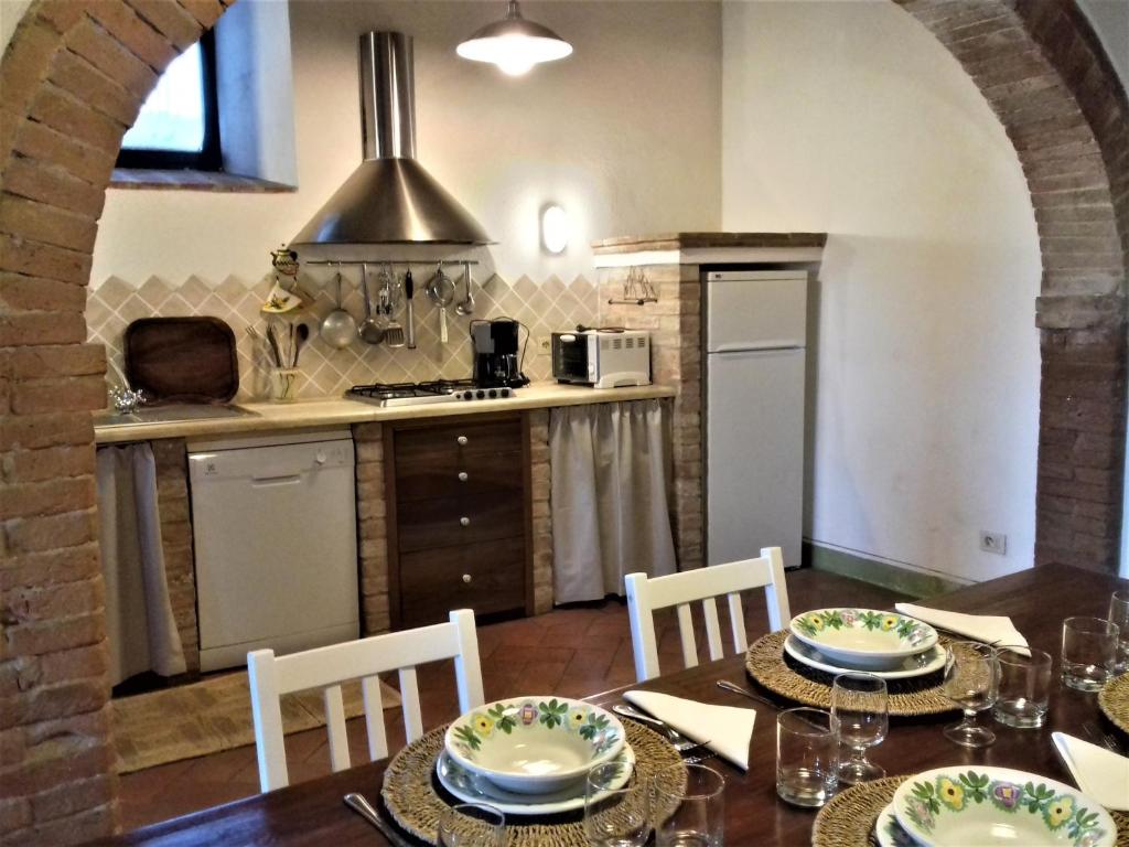 une cuisine et une salle à manger avec une table et des chaises dans l'établissement Pasqui Villas La Capanna accogliente casa in paese con vista piscina WiFi, à San Giovanni dʼAsso