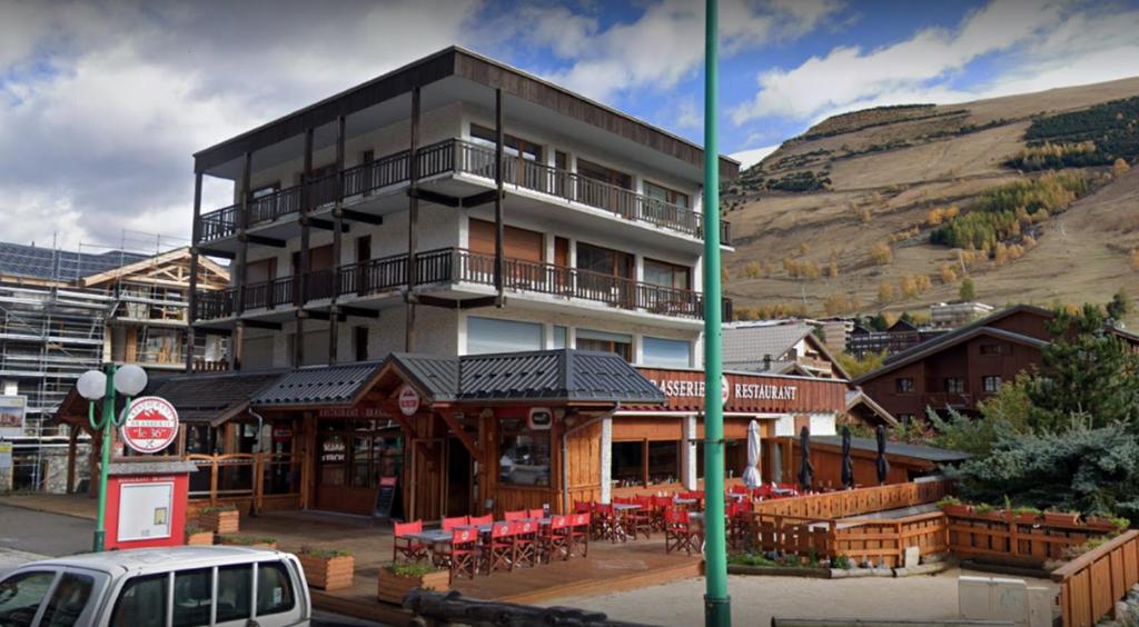 un bâtiment avec un restaurant en face d'une montagne dans l'établissement Le Gilélia, à Les Deux Alpes