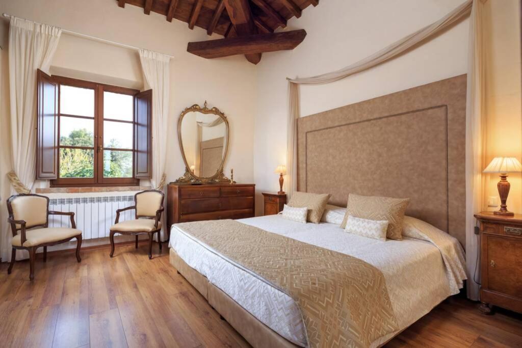 une chambre avec un grand lit et un miroir dans l'établissement Il Fienile di Montesoli, à Villa Montesoli