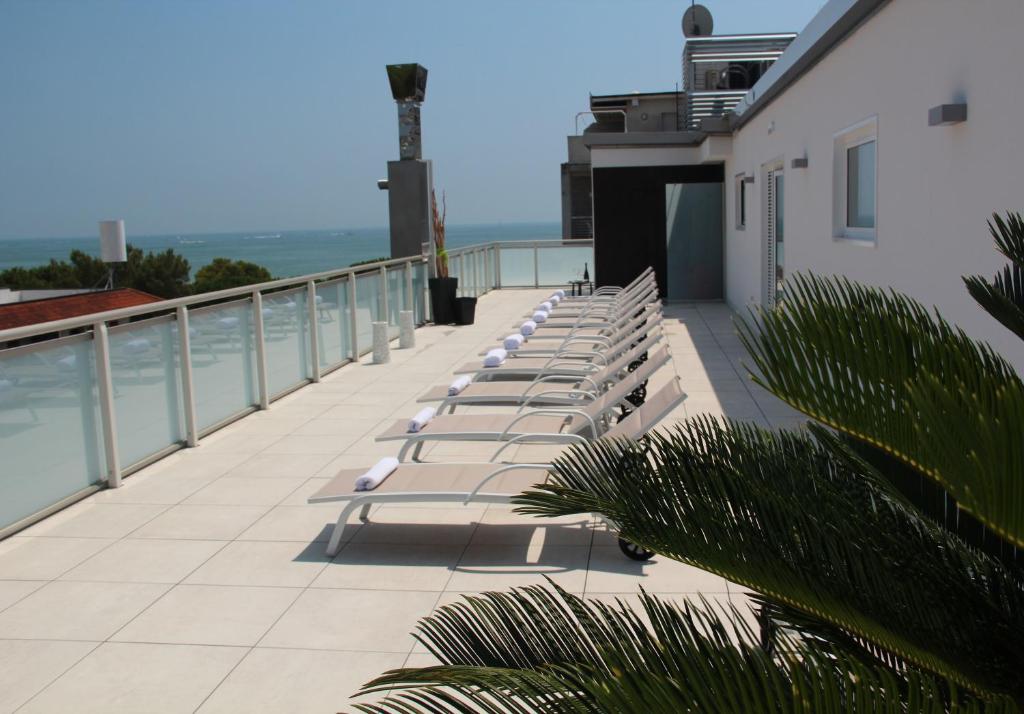 une rangée de bancs assis au-dessus d'un bâtiment dans l'établissement Hotel Castiglione, à Lignano Sabbiadoro