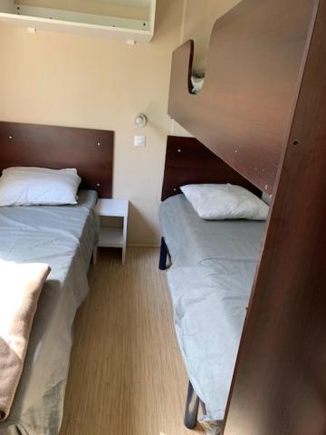 Cette petite chambre comprend 2 lits. dans l'établissement Mobil-Home Saint Cheron, à Saint-Chéron