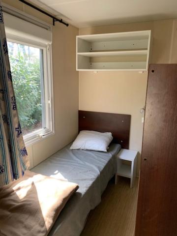 une petite chambre avec un lit et une fenêtre dans l'établissement Mobil-Home Saint Cheron, à Saint-Chéron