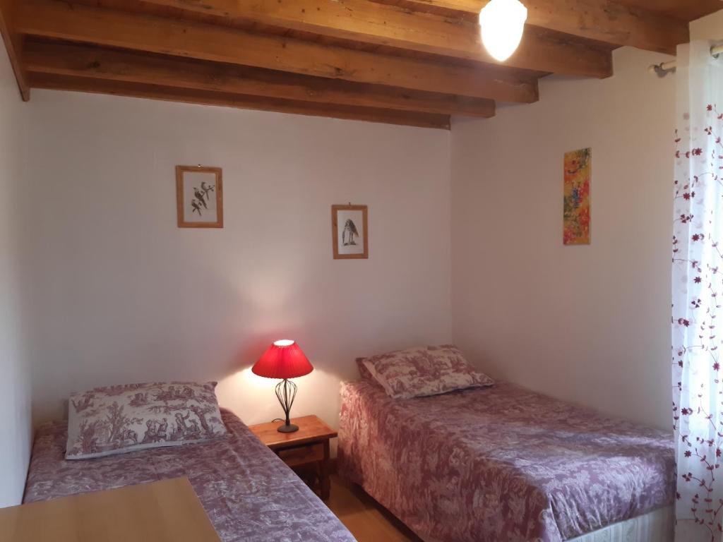 une chambre avec deux lits et une lampe sur une table dans l'établissement Gîtes du Hameau Baylesse, à Saint-Jean-dʼAigues-Vives 18 autres photos