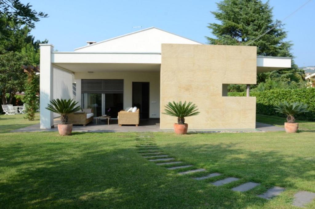 une maison moderne avec une pelouse dans l'établissement Casa Savoia Luxury House, à Bardolino