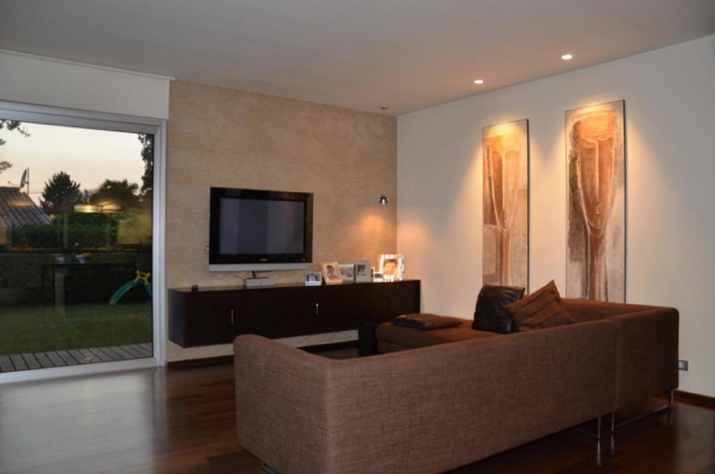 un salon avec un canapé et une télévision à écran plat dans l'établissement Casa Savoia Luxury House, à Bardolino