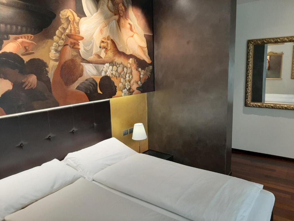 - une chambre avec un tableau mural et un lit dans l'établissement Casa Savoia Luxury House, à Bardolino