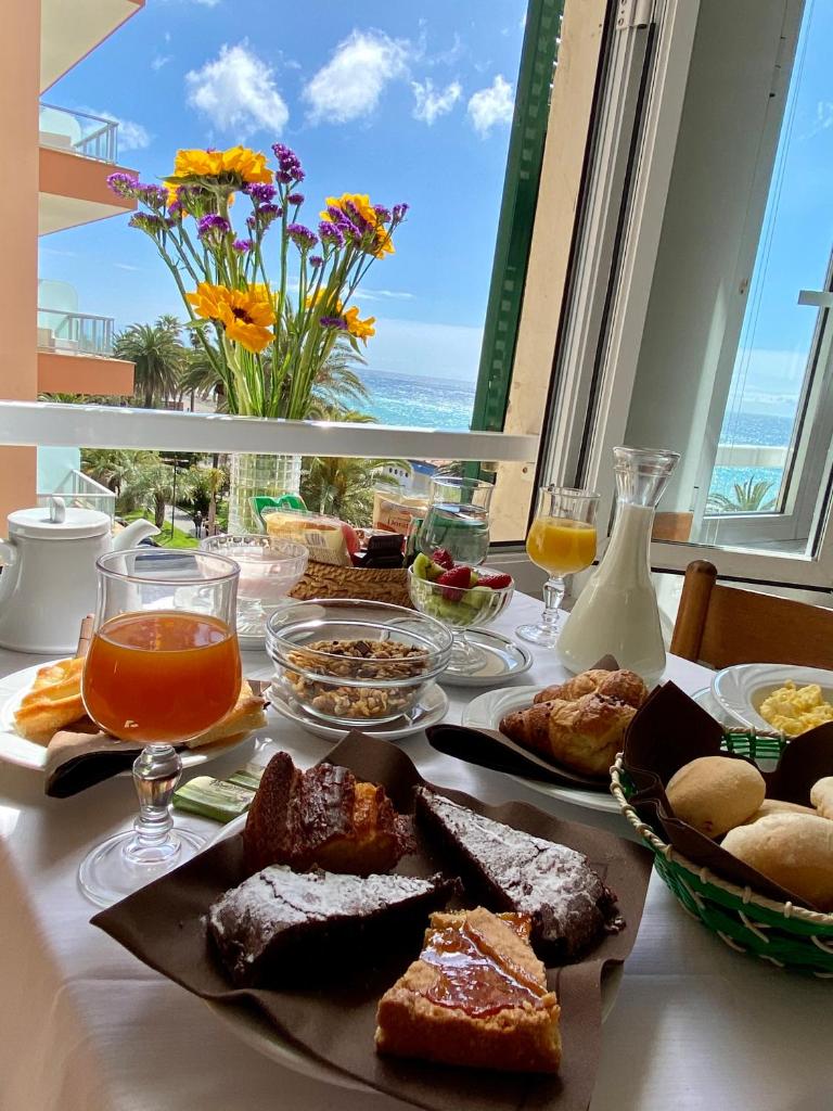 une table avec de la nourriture dessus avec vue sur l'océan dans l'établissement Hotel Alba Chiara, à Finale Ligure 64 autres photos