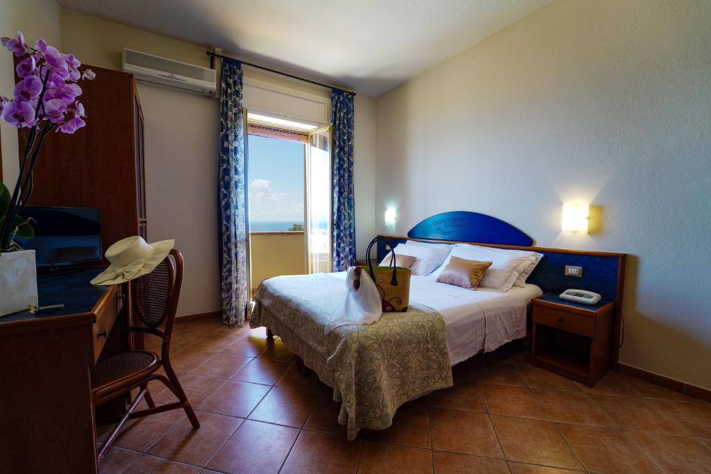 une chambre d'hôtel avec un lit et une fenêtre dans l'établissement Hotel Residence Sciaron, à Capo Vaticano