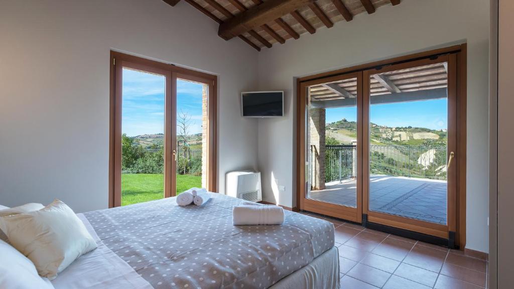 une chambre avec un lit et une porte coulissante en verre dans l'établissement Borgo Da Monte 8, Emma Villas, à Monteprandone