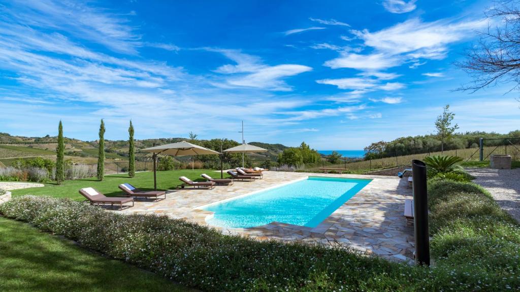 une piscine avec chaises et parasols dans une cour dans l'établissement Borgo Da Monte 8, Emma Villas, à Monteprandone