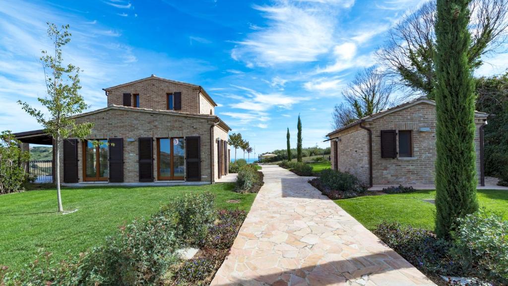 une maison en pierre avec un chemin menant à celle-ci dans l'établissement Borgo Da Monte 8, Emma Villas, à Monteprandone