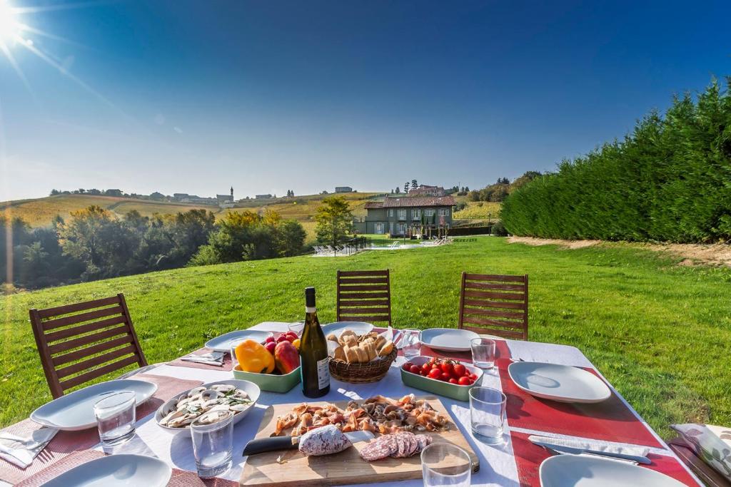 - une table de pique-nique avec de la nourriture et une bouteille de vin dans l'établissement Casale Dell'acero Rosso 10, Emma Villas, à Canelli