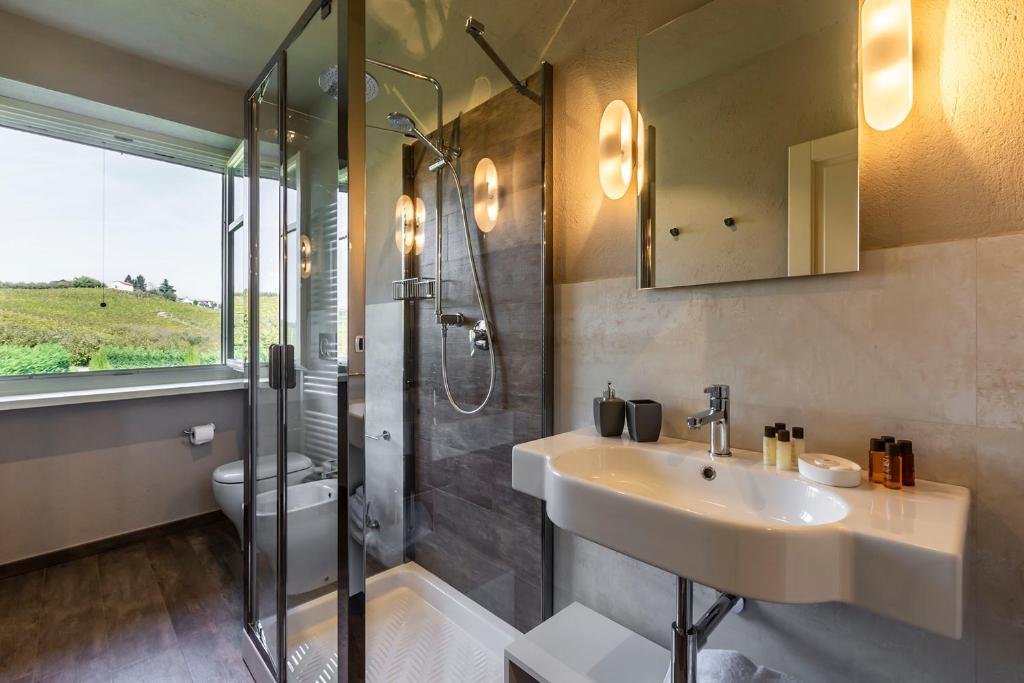 une salle de bain avec un lavabo, une douche et des toilettes dans l'établissement Casale Dell'acero Rosso 10, Emma Villas, à Canelli