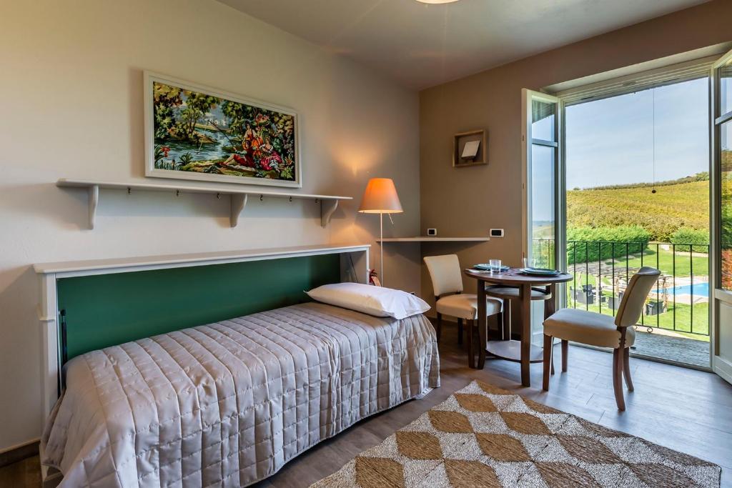 une chambre avec un lit, une table et une fenêtre dans l'établissement Casale Dell'acero Rosso 10, Emma Villas, à Canelli