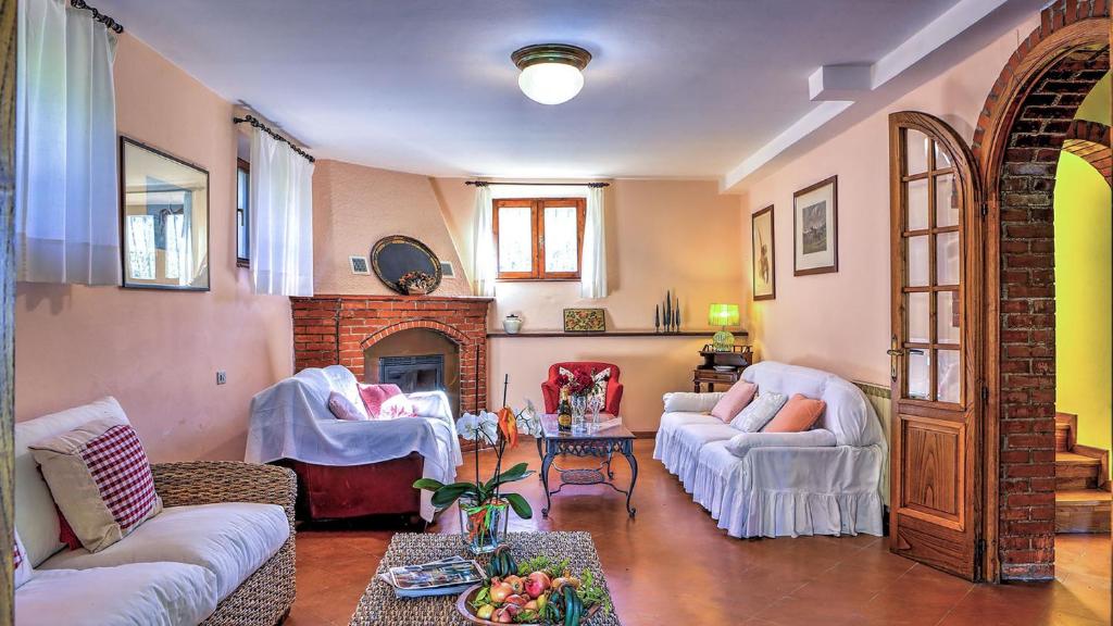 un salon avec deux canapés et une cheminée dans l'établissement CASALE LE CONCE 6, Emma Villas, à Castel del Piano